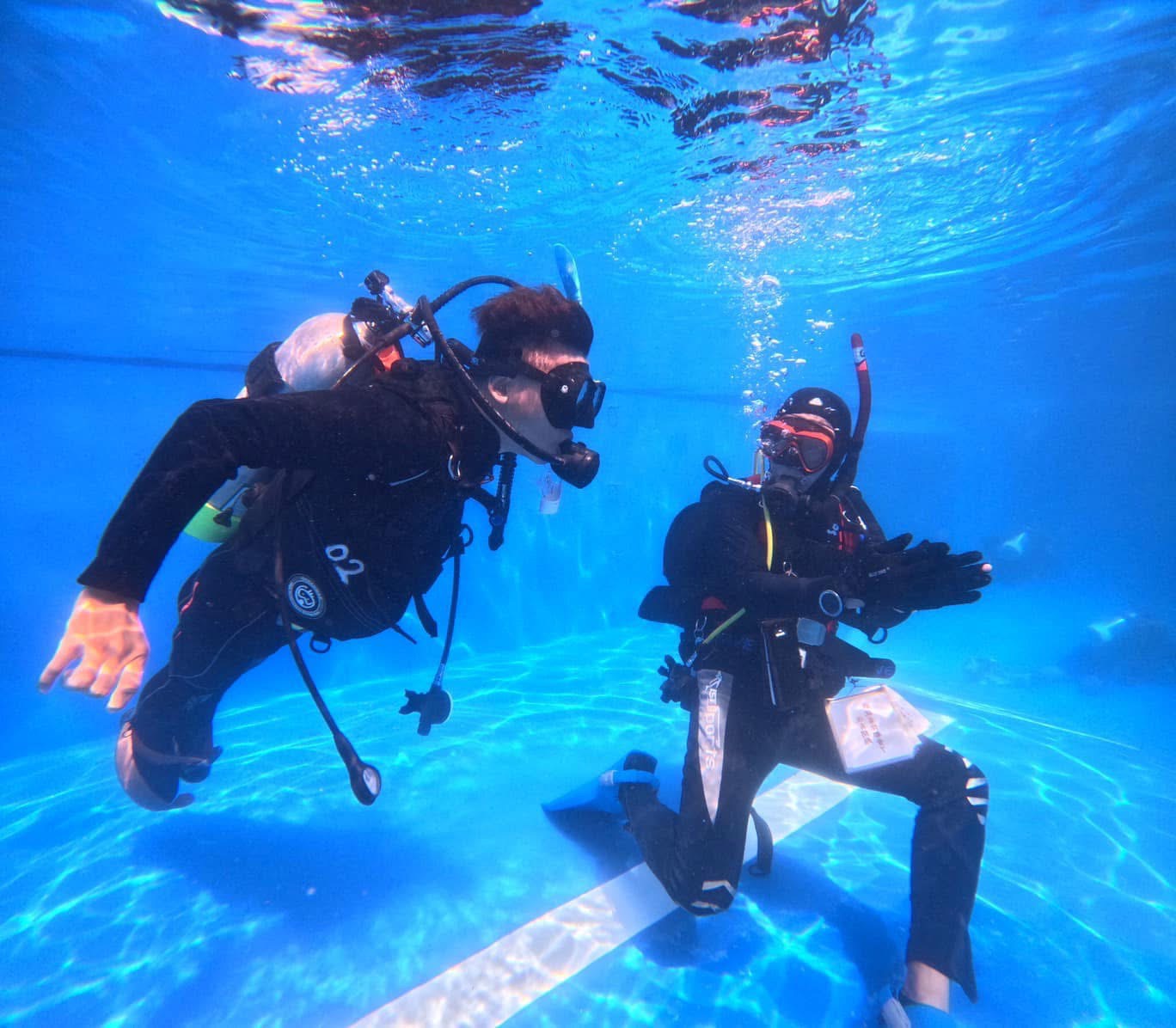教練跪立在池底，用最穩定的姿態，為夢想指引方向。(標題圖檔)